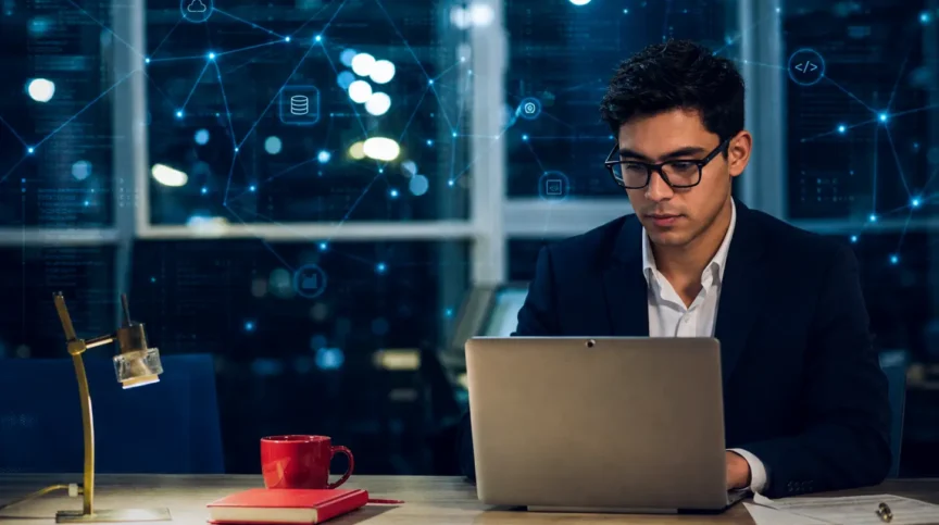 Man working at a laptop with digital security graphics overlaid.