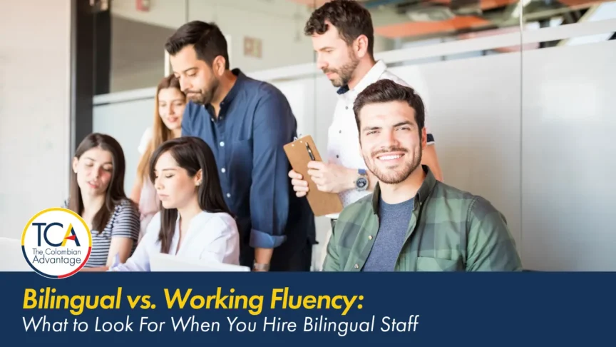 Bilingual team working together around a laptop in an office, with the TCA title "What to Look For When You Hire Bilingual Staff
